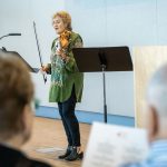 Elizabeth Blumenstock, violinist, talking and playing baroque violin at an event